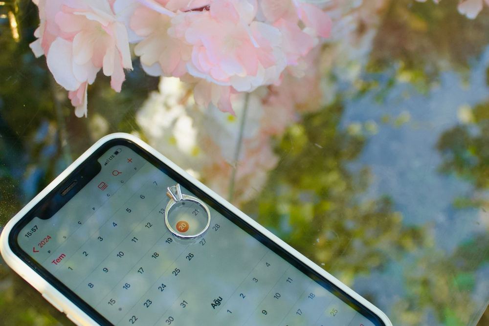 Engagement ring on a phone calendar — planning the wedding date remotely
